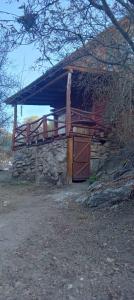 a log cabin with a porch on top of it at Cabañas - sierras de cordoba - Jose de la quintana #2 in José de la Quintana