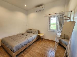 a small bedroom with a bed and a window at 19 House in Ban Khlong Pleo
