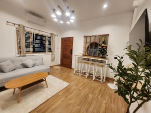 a living room with a couch and a table at 19 House in Ban Khlong Pleo +8 photos
