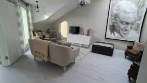 a living room with chairs and a painting on the wall at Spacious & stylish upgraded 1BD Malahide Marina in Malahide