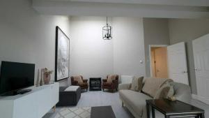 a living room with a couch and a tv at Spacious & stylish upgraded 1BD Malahide Marina in Malahide
