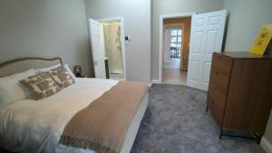 a bedroom with a bed and a wooden dresser at Spacious & stylish upgraded 1BD Malahide Marina in Malahide +6 photos