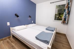a bed in a room with a blue wall at Camping Alpes Dauphiné in Gap