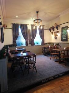 a dining room with tables and chairs and a chandelier at The Waterford Arms in Hartley