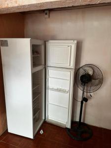 Zimmer mit einem weißen Kühlschrank und einem Ventilator in der Unterkunft Posada en la Playa in Barra del Chuy