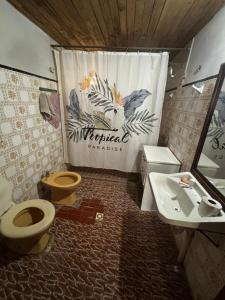 ein Badezimmer mit zwei WCs, einem Waschbecken und einem Vorhang in der Unterkunft Posada en la Playa in Barra del Chuy