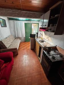 eine Küche mit Herd und einer Couch in einem Zimmer in der Unterkunft Posada en la Playa in Barra del Chuy