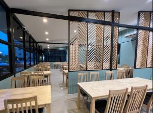 a restaurant with wooden tables and chairs and windows at Eastern View Resort and Pool Villa in Ban Tao Than