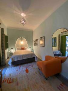 una camera da letto con un letto e un grande specchio di Riad Dar Adal exclusivité 2 à 6 personnes petit déjeuner compris place jemaa El fna a Marrakech