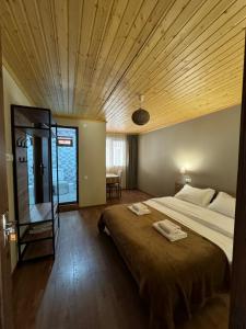 ein Schlafzimmer mit einem großen Bett und einer Holzdecke in der Unterkunft Mestia Views in Mestia