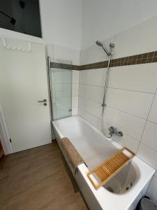 a white bathroom with a tub and a shower at ElbPerle Meißen-Altstadt WLAN Parken WOHLFÜHLEN in Meißen