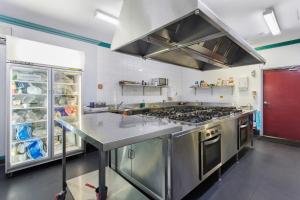 a large kitchen with a stove and a refrigerator at The Emperors Crown Hostel in Perth