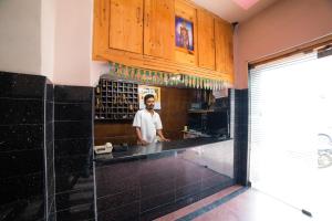 un hombre parado en una cocina con un mostrador en Hotel O Sree Radha Lodge Near Snow World, en Hyderabad