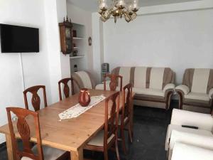 a dining room with a wooden table and chairs at La Cenefilla in Zuheros