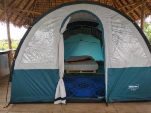 a blue and white tent with a bed in it at Glamping Lakeview Ouidah in Gakpé