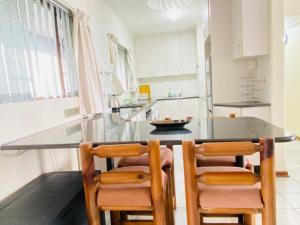 kuchnia ze szklanym stołem i 2 krzesłami w obiekcie Beach Front Holiday Apartment, Stella Maris, Beach Road, Amanzimtoti w mieście Amanzimtoti