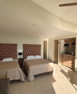 a hotel room with two beds and a kitchen at Suite Torres Gemelas Acapulco in Acapulco