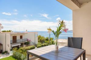 Una mesa con un jarrón de flores en un balcón. en Apartment Bikin 2, en Brela