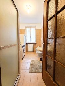 a bathroom with a toilet and a sink and a door at CàGrande in Colombara