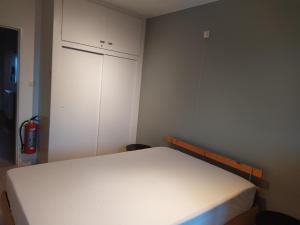 a bedroom with a white bed and a white cabinet at Residentie Rapallo in Middelkerke