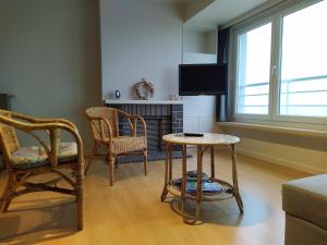a living room with a table and two chairs and a tv at Residentie Rapallo in Middelkerke