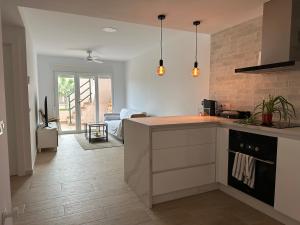 ベラにあるAtico duplex con piscina privada, solárium y barbacoaのキッチン(カウンタートップ付)、リビングルーム