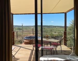 a patio with a table and chairs on a deck at Lodge & Bain Relaxant in Campagnan