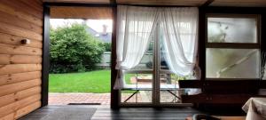 an open door to a patio with a view of a yard at Domki na Chabrowej in Augustów