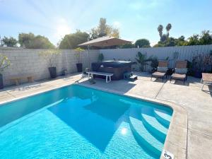 a swimming pool with a grill and chairs next to a fence at Disneyland Retreat-Pool Spa Game in Anaheim