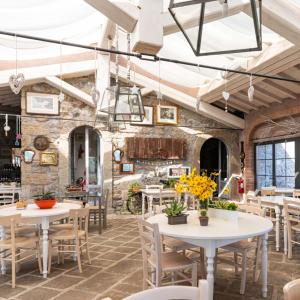 a restaurant with tables and chairs and a stone wall at L'orto di Hans in Soriano nel Cimino