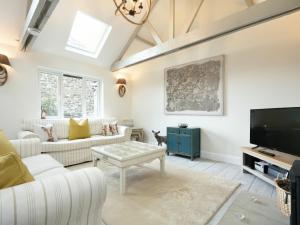 a living room with white furniture and a flat screen tv at East Farm Croft in Alnwick