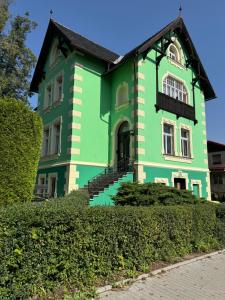 a green house with a black roof at Apartamenty Astor - Słoneczny in Szczawno-Zdrój