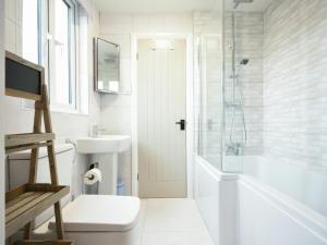 a white bathroom with a sink and a shower at East Farm Croft in Alnwick +5 photos
