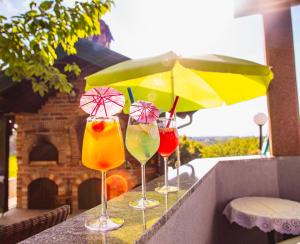 a row of wine glasses with umbrellas on a ledge at KUĆA ZA ODMOR JURINO GNIJEZDO in Jarki Horvatićevi
