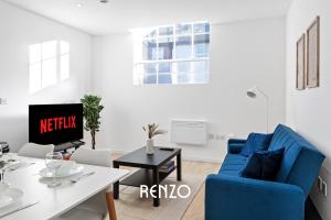 a living room with a blue couch and a table at Bright and Modern 2-bed Home in Newark on-Trent by Renzo, Free Parking, Sleeps 5! in Newark upon Trent