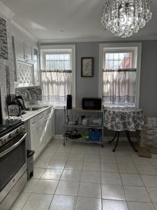 a kitchen with white cabinets and a chandelier at BK Studio 422 in Brooklyn