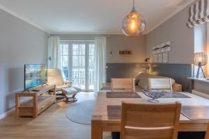 Una sala de estar con una mesa y un comedor. en Ahoi, en Sankt Peter-Ording