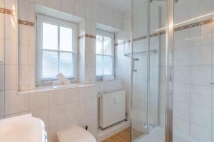 Un baño blanco con ducha y WC. en Ahoi, en Sankt Peter-Ording 15 fotos más