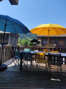 a table and chairs with umbrellas on a deck at Chalet Robin - spa- multipass- terrain de pétanque in Morzine