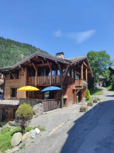 a large wooden building with umbrellas on a street at Chalet Robin - spa- multipass- terrain de pétanque in Morzine