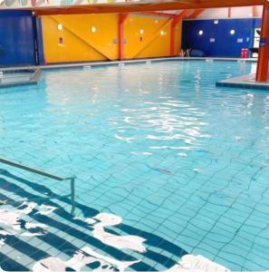 a large swimming pool with blue tiles on the floor at Harwich - Caravan - Sleeps 10 - Garden - Pool in Harwich