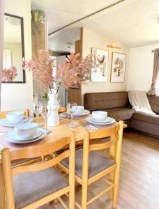 a wooden table with chairs and a dining room at Harwich - Caravan - Sleeps 10 - Garden - Pool in Harwich