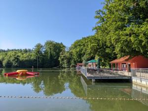 a boat on the water next to a dock at Tinyhaus am See in Wemding