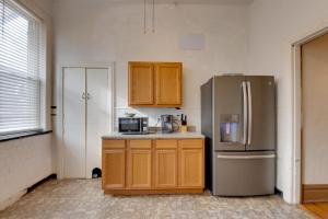 a kitchen with a stainless steel refrigerator and wooden cabinets at 2 Mi to Dtwn Apartment in Saint Louis in Soulard