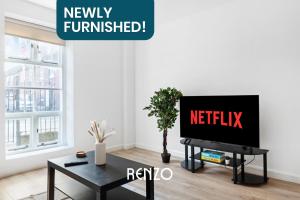 a living room with a tv and a table at Spacious 1-bed Apartment in Newark on-Trent by Renzo, Central Location, Free Parking! in Newark upon Trent