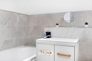 a bathroom with a sink and a tub and a mirror at Spacious 1-bed Apartment in Newark on-Trent by Renzo, Central Location, Free Parking! in Newark upon Trent