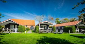 a house with a yard with a picnic table at Lodges De Driesprong Domburg in Domburg