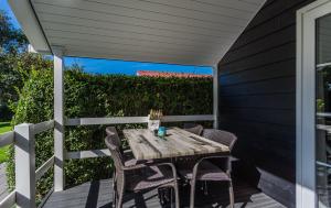 a wooden table and chairs on a patio at Lodges De Driesprong Domburg in Domburg +174 photos