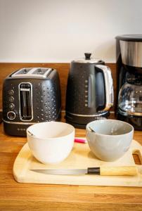 Appartement Royal séjour, Parking gratuit في سانت كونتان: طبقين بيض على لوح تقطيع بجانب محمصة