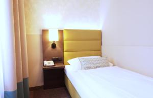 Postel nebo postele na pokoji v ubytování Drei Kronen Hotel Wien City